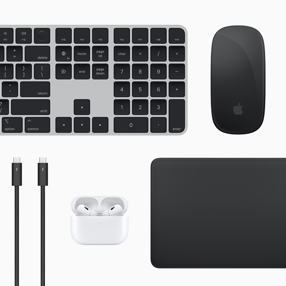 Top view of Mac accessories: Magic Keyboard, Magic Mouse, Magic Trackpad, AirPods, and Thunderbolt cables