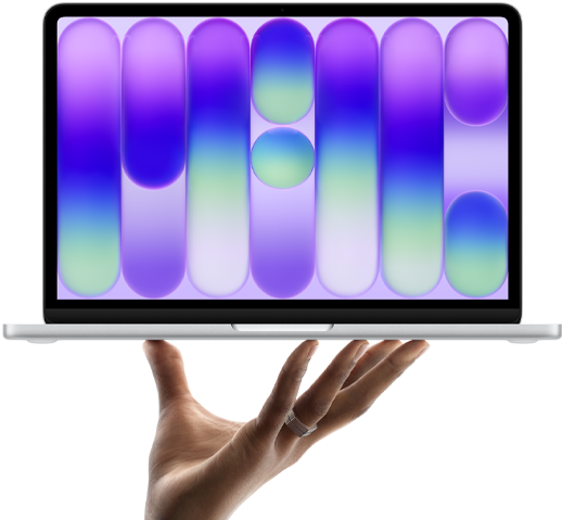 MacBook Neo in silver color, balanced on fingertips of open hand, screen displaying colorful abstract pattern