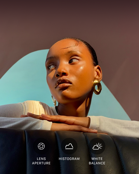 Close up portrait of a well-lit model with a colorful background, demonstrating the pro camera system's Pro controls UI: Lens Aperture, Histogram, White Balance
