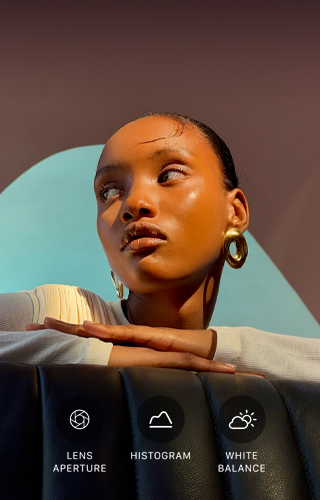 Close up portrait of a well-lit model with a colorful background, demonstrating the pro camera system's Pro controls UI: Lens Aperture, Histogram, White Balance