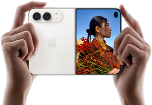 iPhone Duo, Star White color, held by two hands in horizontal orientation, unfolded, left panel shows 48MP Dual Fusion rear cameras, right panel shows person getting their picture taken on outer display, the subject of the photo is able to see their face as their picture is getting taken using Duo Preview